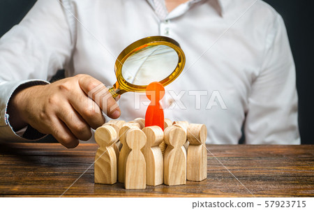 A man is studying the red figure of a man at the head of a crowd. Identify disloyal, repression, dissent. toxic, non-competent worker. Search for the organizer and leader of the protests. Crime. A man is studying the red figure of a man at the head of a crowd. Identify disloyal, repression, dissent. toxic, non-competent worker. Search for the organizer and leader of the protests. Crime. 57923715