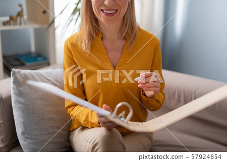 Cropped photo of pretty smiling female psychology holding folder in arms Cropped photo of pretty smiling female psychology holding folder in arms 57924854