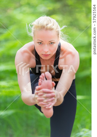 Lady practicing yoga in the nature. Lady practicing yoga in the nature. 57925564