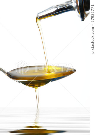 olive oil on spoon in white background olive oil on spoon in white background 57925771