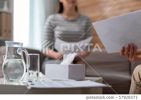 Jug with water and glass situating on table near napkins in cabinet Jug with water and glass situating on table near napkins in cabinet 57926371