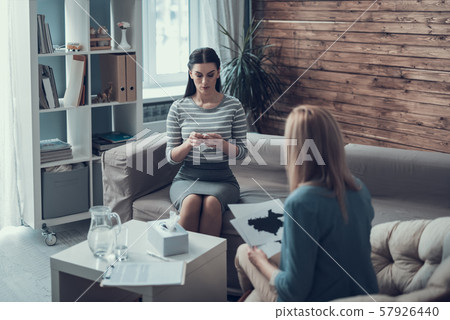 Female psychologist analyzing psycological test for patient in therapy cabinet 57926440