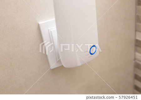 Wifi home repeater plugged in closeup. Wifi home repeater plugged in closeup. 57926451