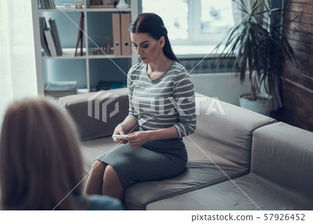 Woman listening to her psychologist and sitting on the couch indoors 57926452