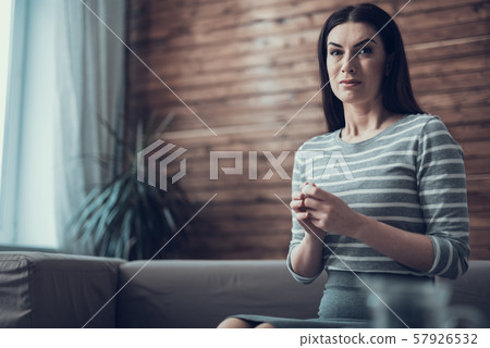 Unhappy Caucasian woman looking at camera indoors Unhappy Caucasian woman looking at camera indoors 57926532