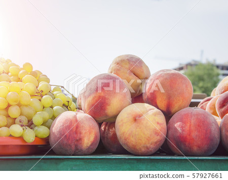 ripe peaches with green grapes at an outdoor market 57927661