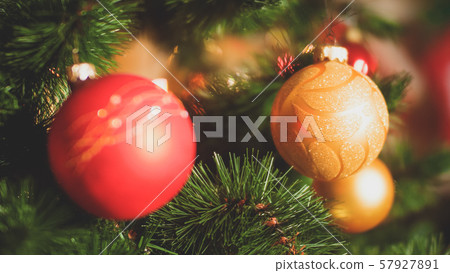 Closeup toned photo of needles and colorful baubles on Christmas tree. Perfect background for winter Closeup toned photo of needles and colorful baubles on Christmas tree. Perfect background for winter 57927891