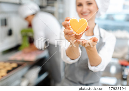 Pastry chef baking heart shaped cookies 57928194