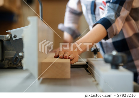 Closeup of carpenter woman at circular cutter Closeup of carpenter woman at circular cutter 57928216