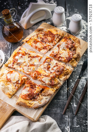 Peperroni pizza on a cutting board on a dark Peperroni pizza on a cutting board on a dark 57928718