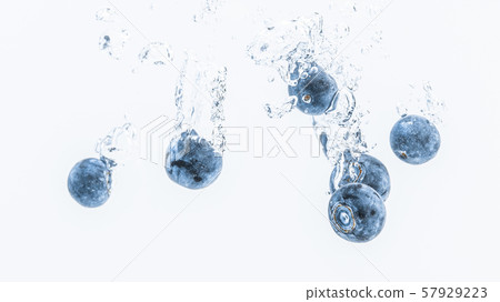 Fresh blueberries falling in water on white Fresh blueberries falling in water on white 57929223