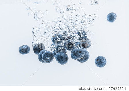 Fresh blueberries falling in water on white Fresh blueberries falling in water on white 57929224