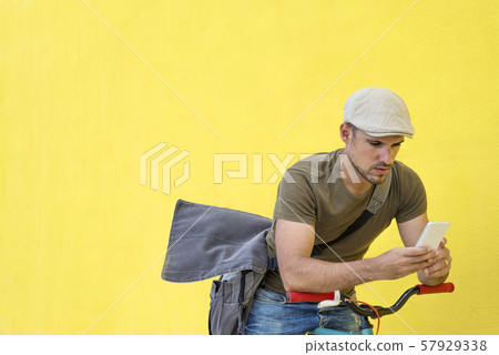 Side view of a young adult man with a vintage bike Side view of a young adult man with a vintage bike 57929338
