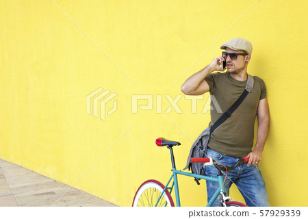 Side view of a young adult man with a vintage bike Side view of a young adult man with a vintage bike 57929339