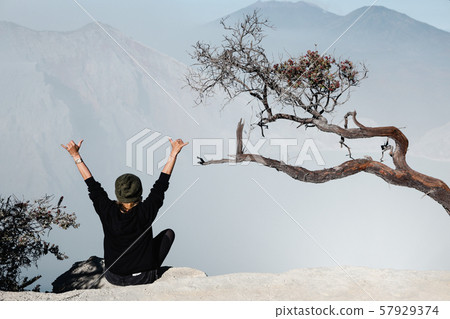 Girl sit on rock above volcano Kawah Ijen acid 57929374