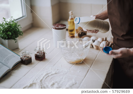 Close up of a pleasant woman cooking pancakes Close up of a pleasant woman cooking pancakes 57929689
