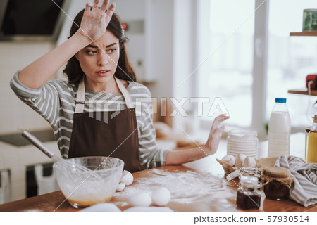 Confused young woman is cooking homemade pastry Confused young woman is cooking homemade pastry 57930514