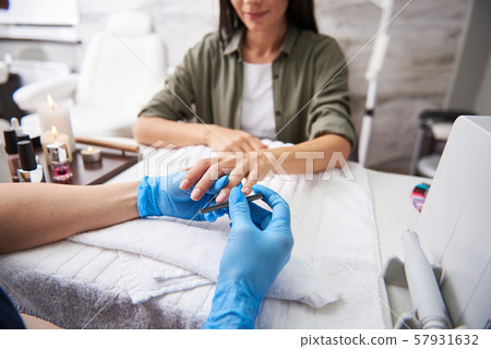 Professional manicurist buffing lady nails in order to make them more shiny 57931632
