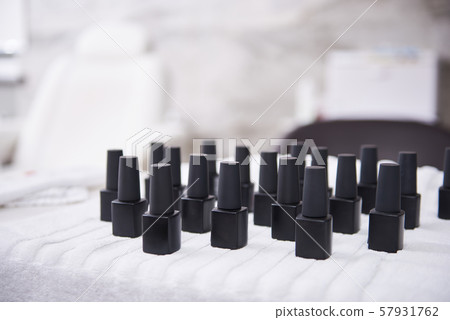 Many black bottles of nail varnish on white soft towel 57931762