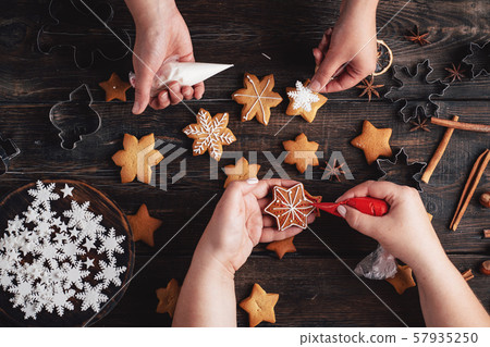 Friends decorating christmas gingerbread cookies Friends decorating christmas gingerbread cookies 57935250