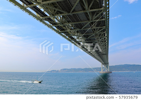 一條小船駛過明石海峽大橋下 57935679