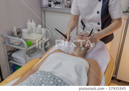 Professional beautician does the procedure for a Professional beautician does the procedure for a 57935845