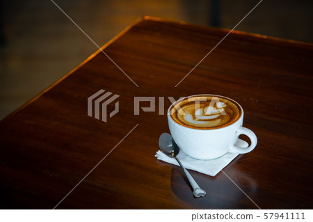 Hot art Latte Coffee in a cup on wooden table and Coffee shop blur background 57941111