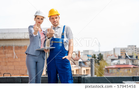 Architect and Construction worker on site giving the finger Architect and Construction worker on site giving the finger 57945458