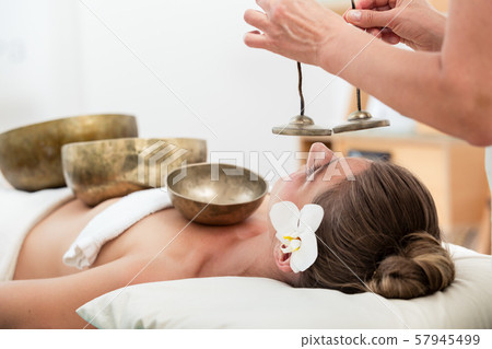 Young woman undergoing sound therapy 57945499