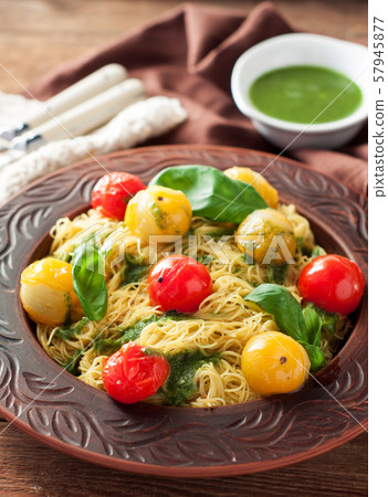 Spaghetti with stewed tomatoes, pesto, basil 57945877