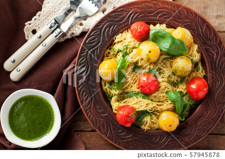 Spaghetti with stewed tomatoes, pesto, basil Spaghetti with stewed tomatoes, pesto, basil 57945878