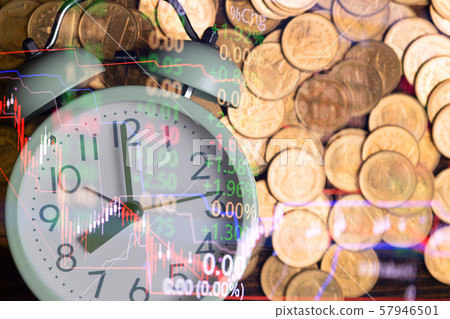 Alarm clock and coins stacks on working table in 57946501