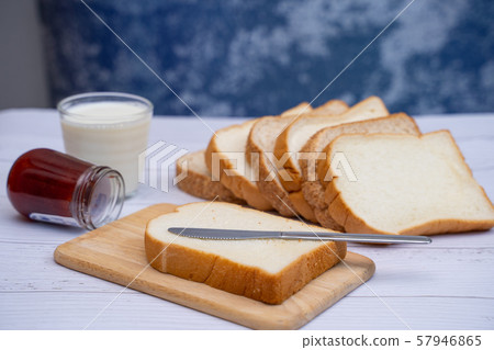sliced bread with jam and milk for breakfast 57946865