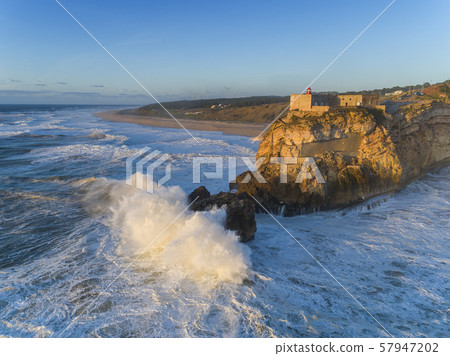 Lighthouse and big waves at in Nazare 57947202