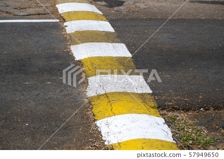 Asphalt Speed Bump on the Local Asphalt Road. Asphalt Speed Bump on the Local Asphalt Road. 57949650