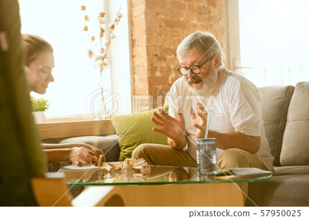 Senior man doing his wooden constructor at home - concept of home studying 57950025