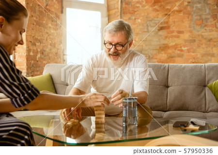 Senior man doing his wooden constructor at home - concept of home studying 57950336