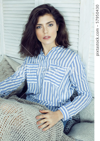 young pretty brunette woman in her bedroom sitting at window. lifestyle and people concept at home 57950430