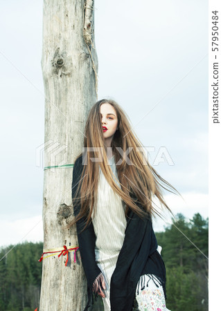 fashion style dressed girl with dreamcatcher outside in field, making witchcraft ritual at halloween 57950484