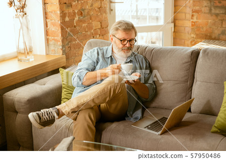 Senior man working with laptop at home - concept of home studying 57950486