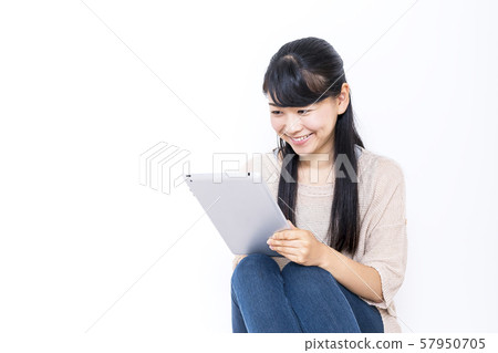 Smiling woman looking at tablet Smiling woman looking at tablet 57950705