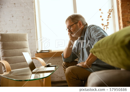 Senior man working with laptop at home - concept of home studying 57950886