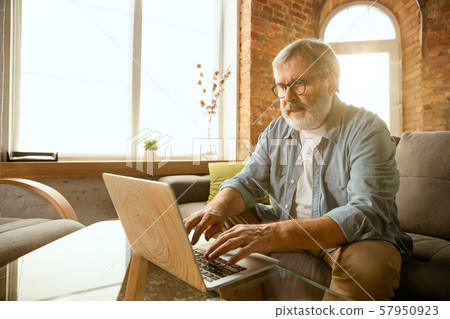 Senior man working with laptop at home - concept of home studying 57950923