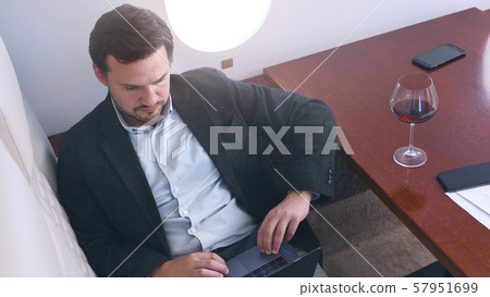 Businessman works on private plane Businessman works on private plane 57951699