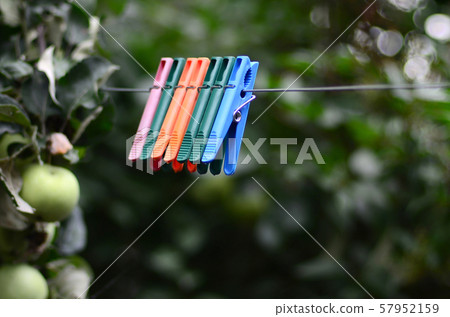 Clothespins on a rope hanging outside house and 57952159