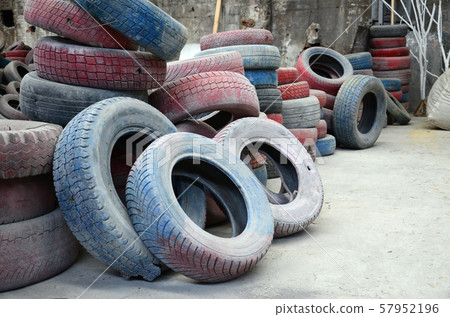 A picture of many old used tires left on a waste A picture of many old used tires left on a waste 57952196
