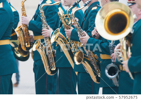 A wind instrument parade - people in green costumes holding saxophone 57952675