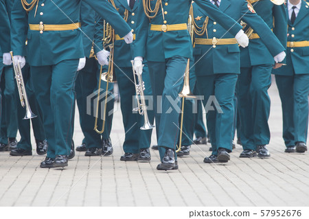 A wind instrument parade - people in green costumes walking on the street holding musical 57952676