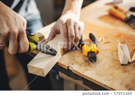 The carpenter works with a tree The carpenter works with a tree 57953169