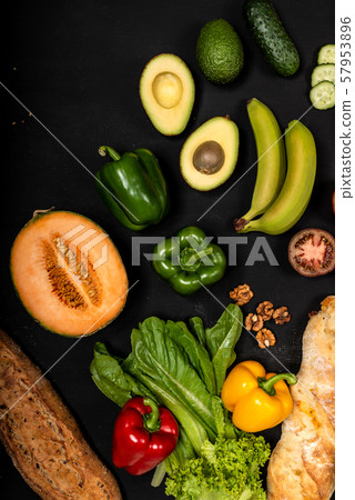 Different vegetables and baguette on a black background. Vegan healthy food Different vegetables and baguette on a black background. Vegan healthy food 57953896